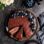 černicovo čokoládový tart nakrájaný na čiernom podklade